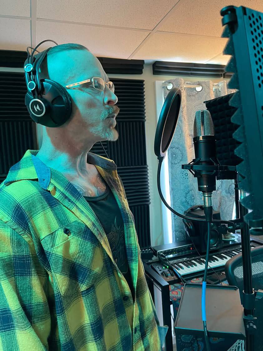 Jay Miller singing into studio microphone with pop filter